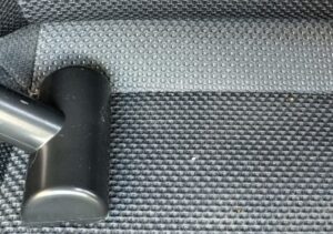 車内のシートを床用アクセサリーを使って掃除している
