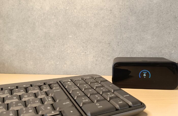 デスク上のキーボードの奥に設置されたAnker Nano Charging Station (100W)。正面のディスプレイに「6W」と出力が表示されている様子