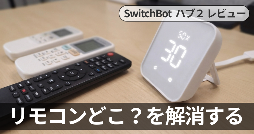 SwitchBotハブ2と複数の赤外線リモコンが置かれたデスク、および「リモコンどこ？を解消する」のテキスト画像