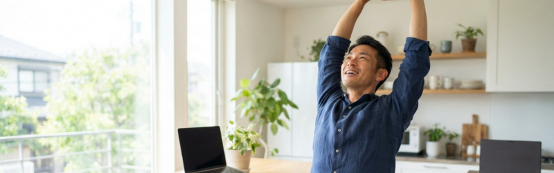 動画視聴休憩でリラックスできた男性が体を伸ばしている様子